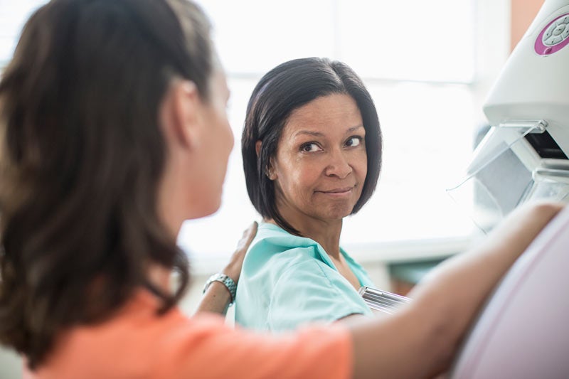 Nurse prepping patient for mammogram