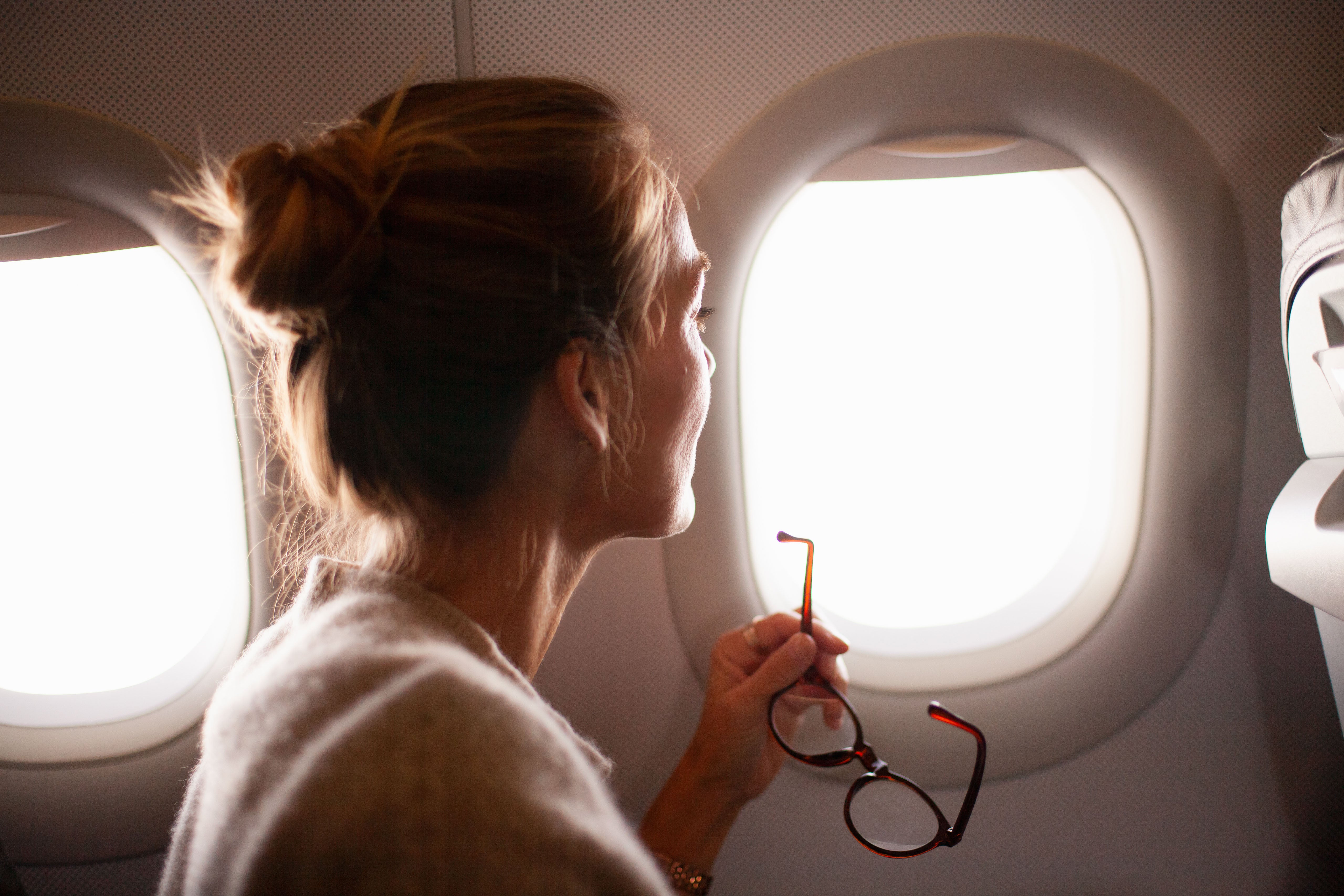 Woman on airplane looking out window