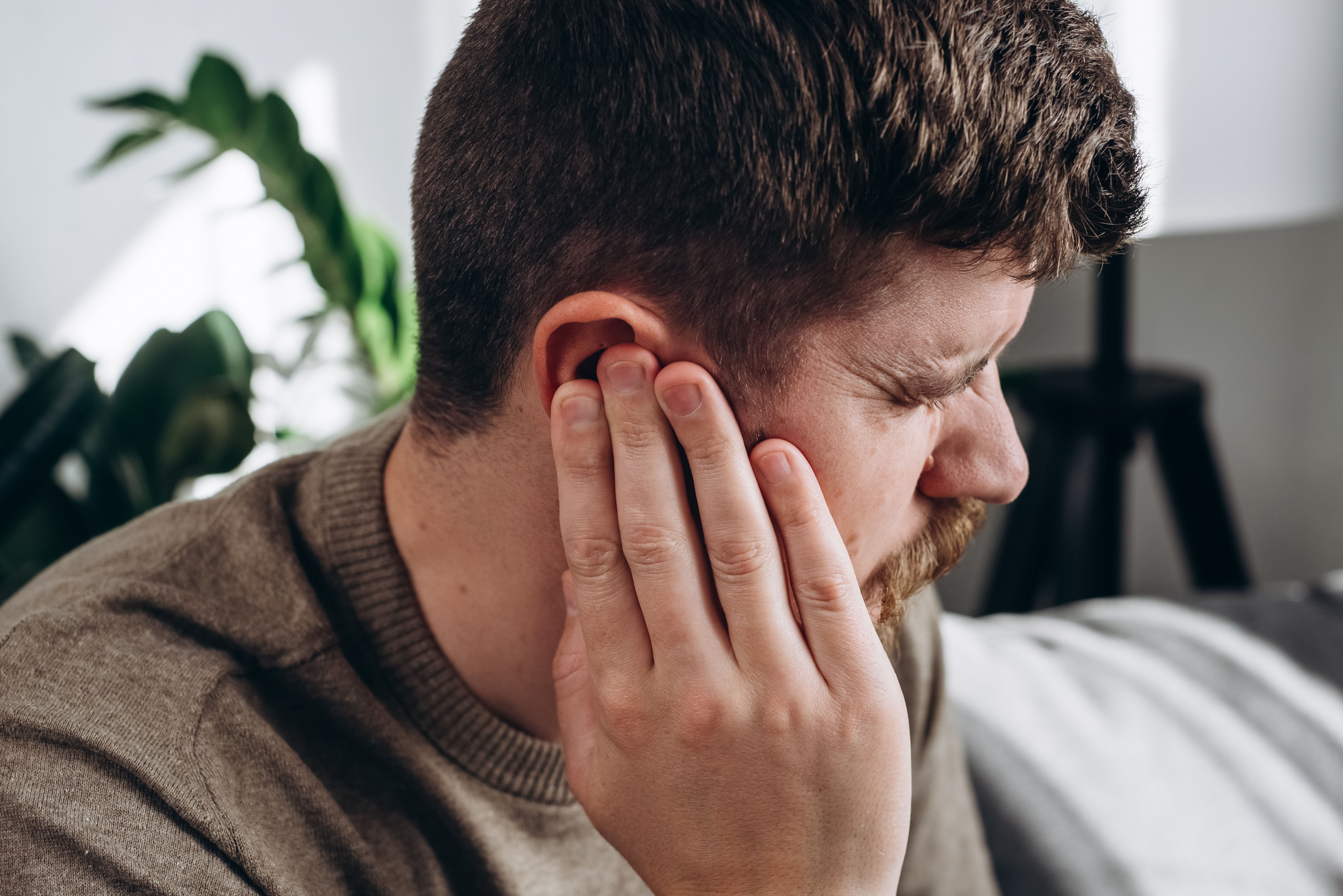 Profile of man holding his hands to his ears
