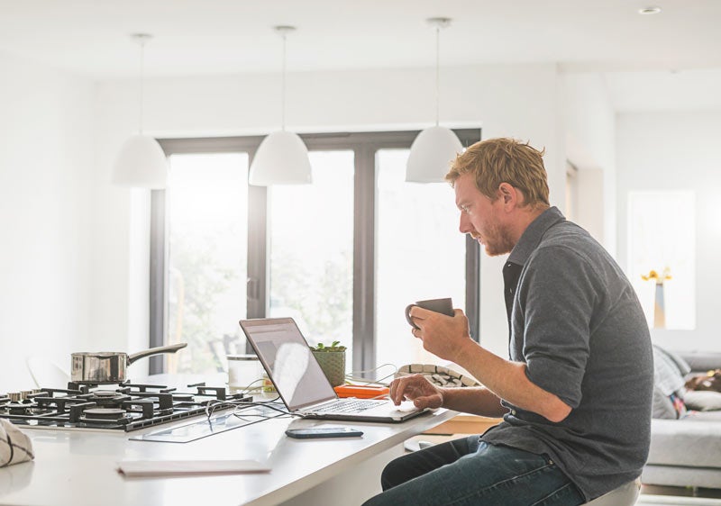 A man uses a laptop computer at home