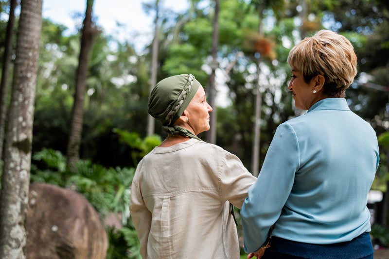 Woman with breast cancer walking with friend
