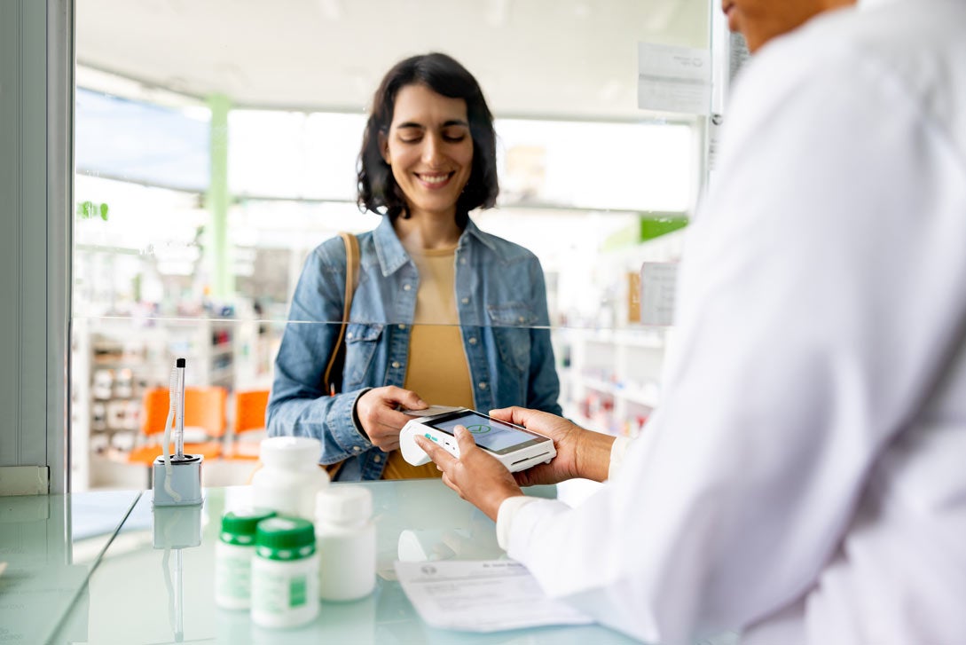 A woman picks up her medicine at the pharmacy