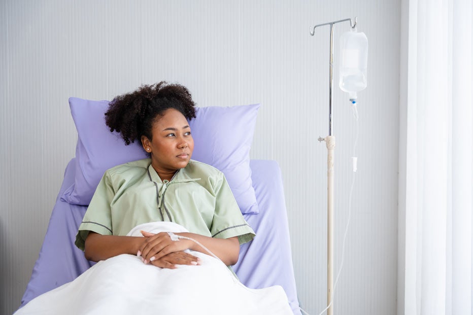 Surgeon talks with female patient in hospital bed