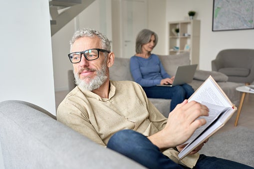 Senior man looking up from book