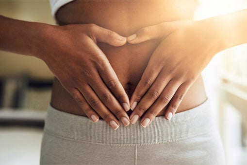 Woman holding hands to stomach