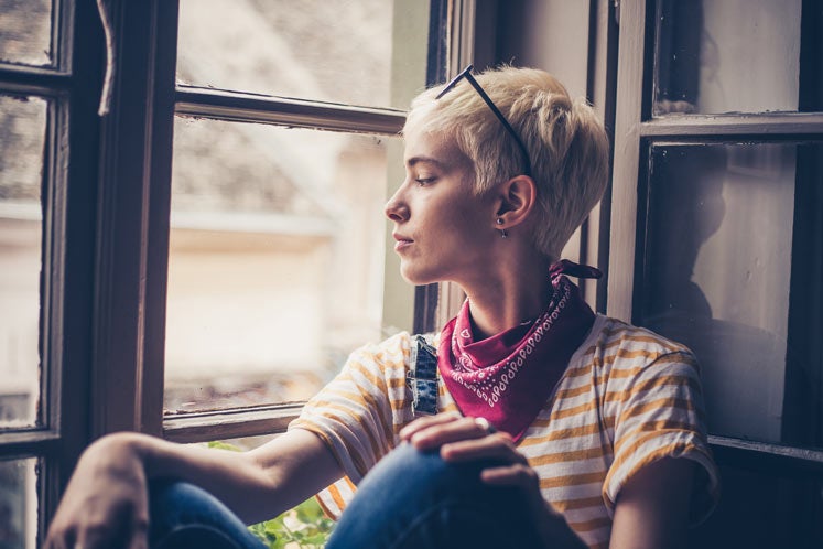 Profile view of blond woman looking through window