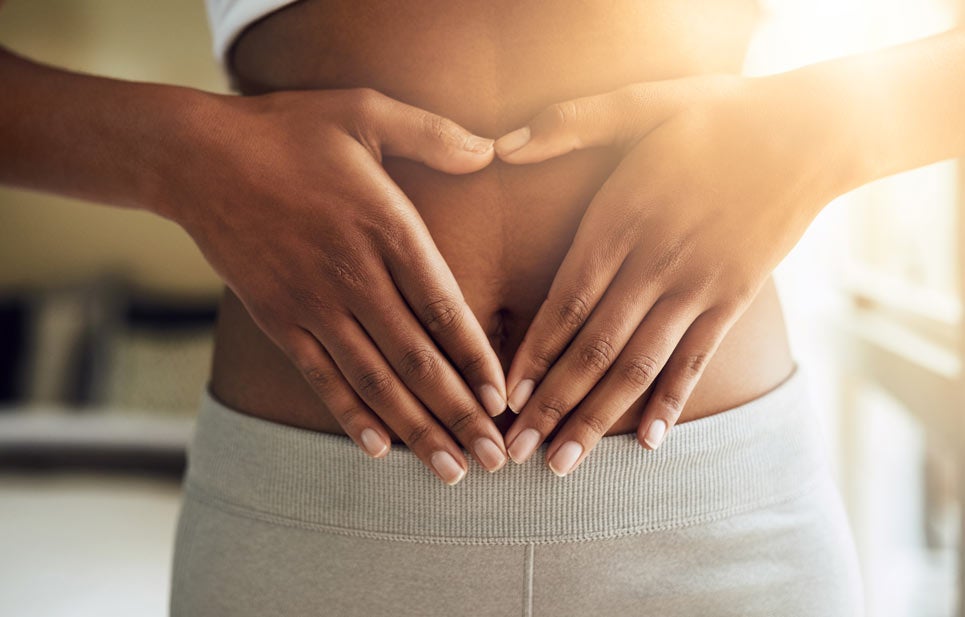 Cropped visual of a woman gently touching her stomach