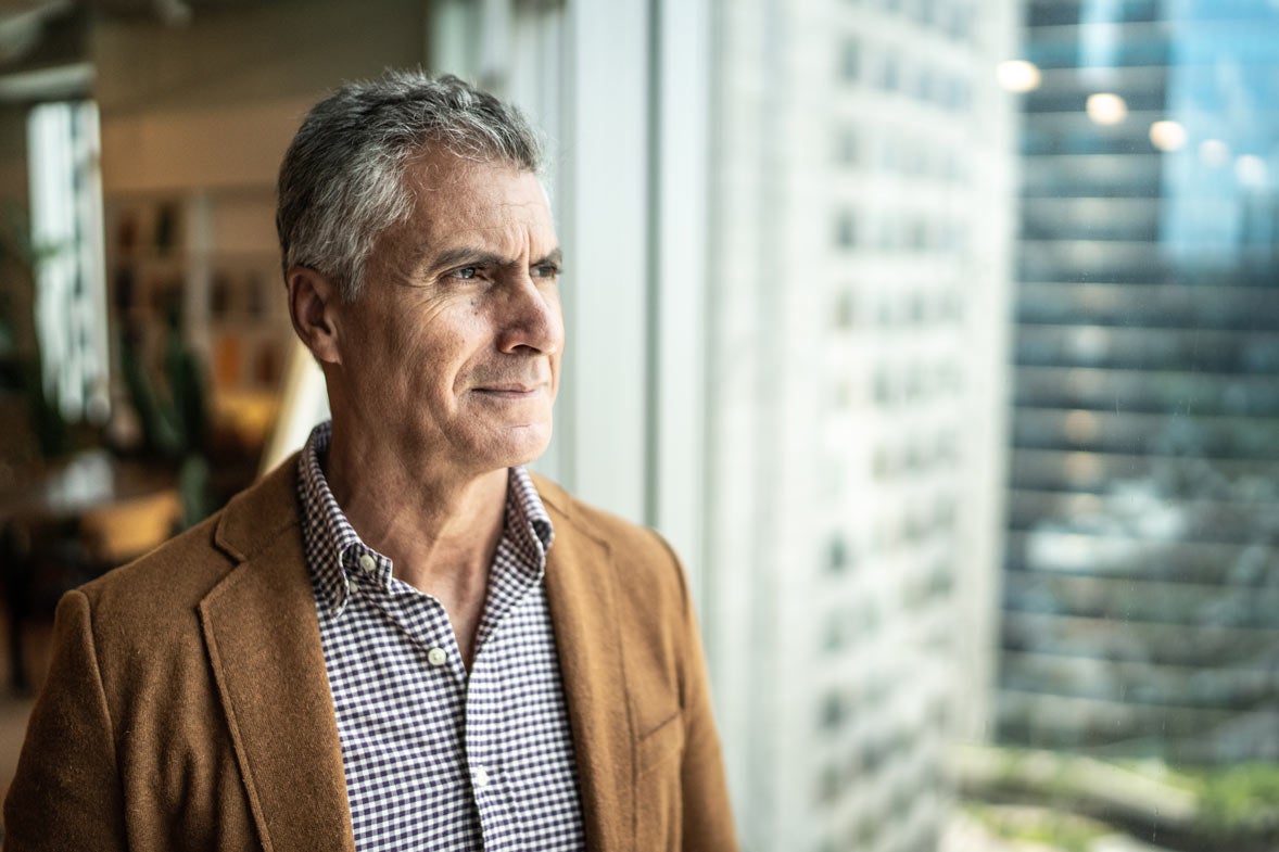 Man in tan blazer staring out window