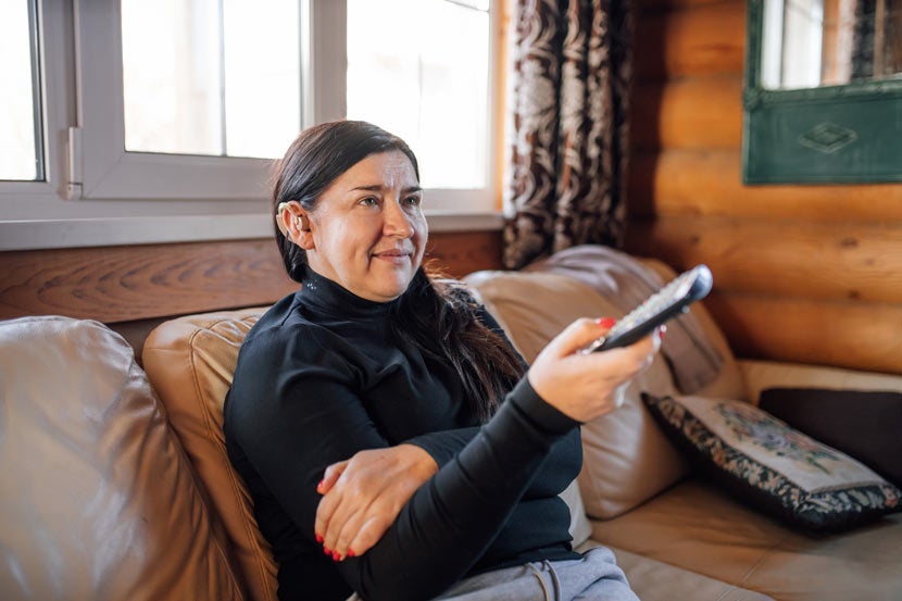 Woman with hearing aid watching TV