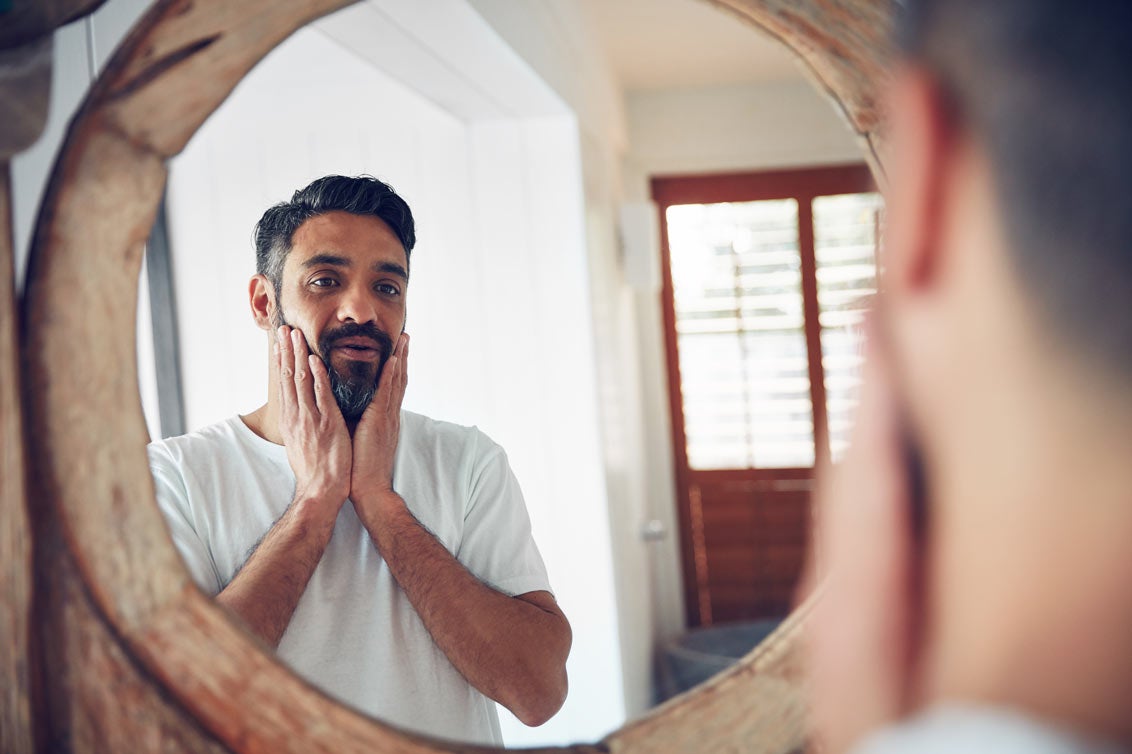 Man looking worried in mirror